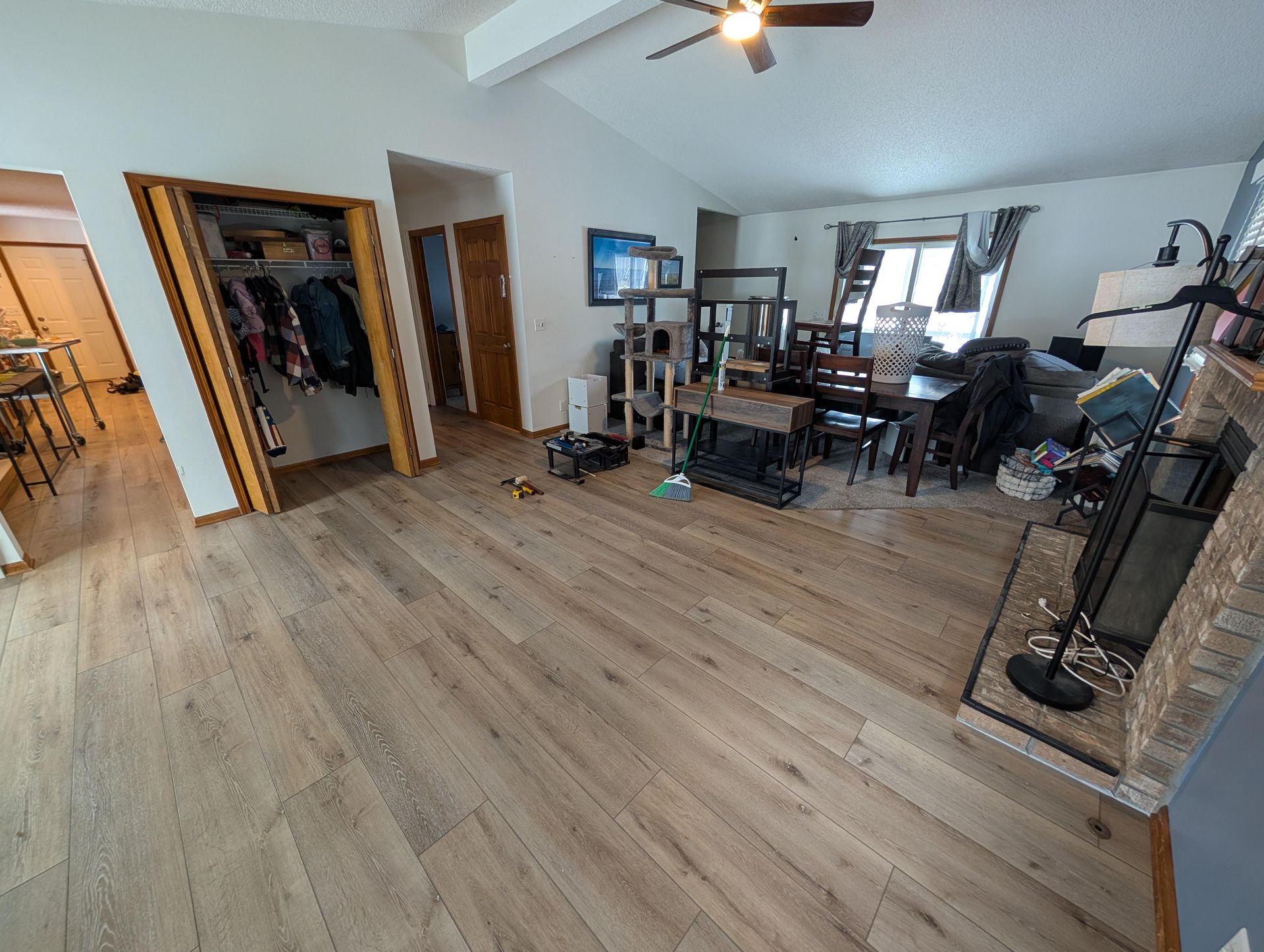 A living room with hardwood floors , a fireplace and a ceiling fan.