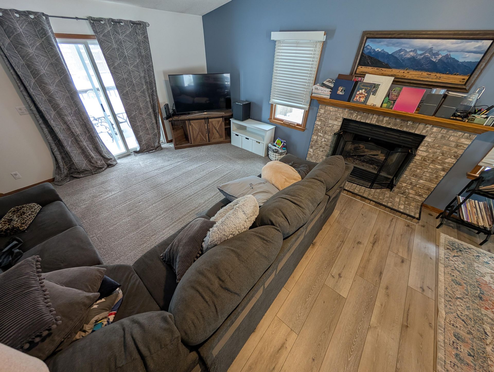 A living room with a couch , fireplace and television.