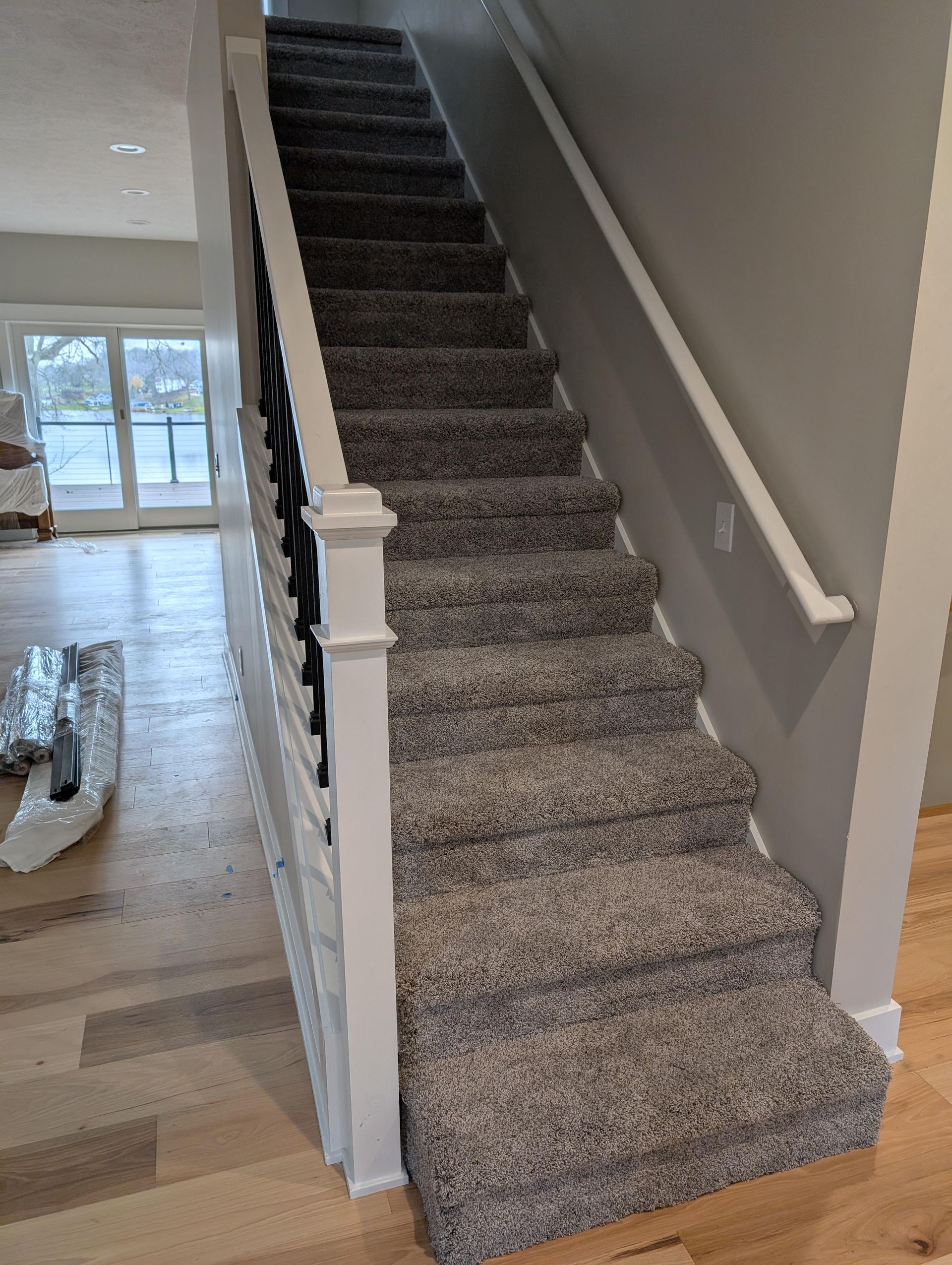 A staircase with carpeted steps and a white railing in a living room.