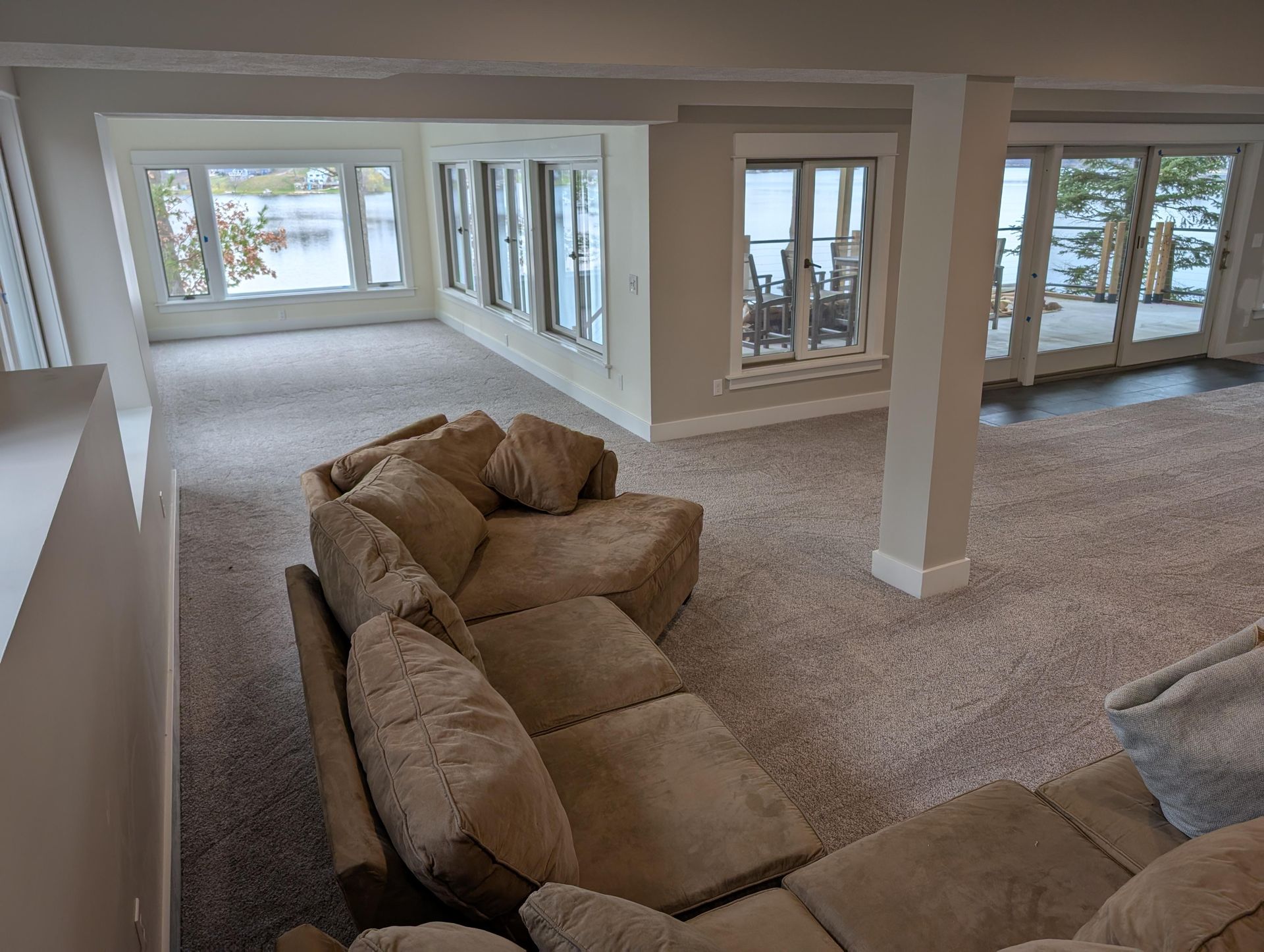 A living room with a couch and chairs and a lot of windows