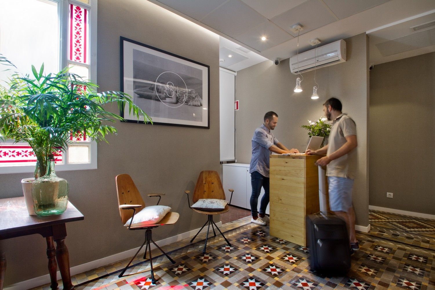 Dos hombres están de pie ante un mostrador en el vestíbulo de un hotel.