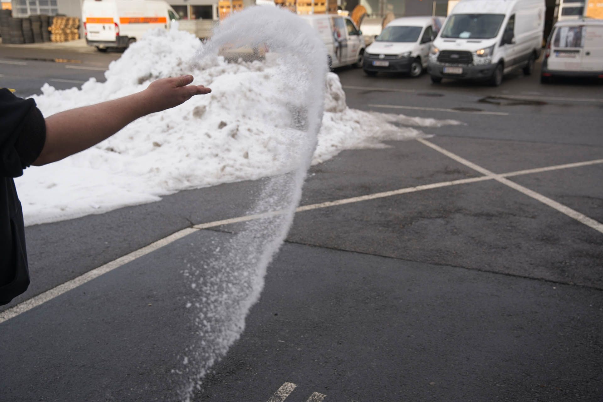 Eine Person reinigt eine Ziegelterrasse mit einem Hochdruckreiniger.
