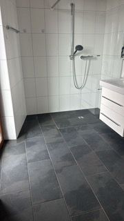 Frau in grünem Hemd wischt Aufzugspiegel mit blauem Tuch ab.