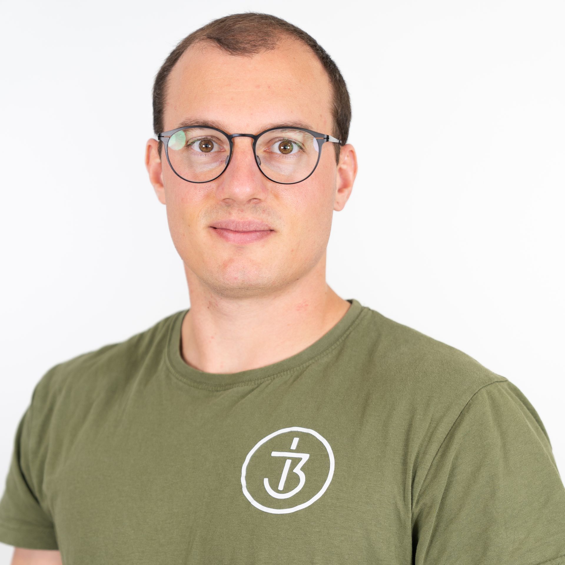 Ein Mann mit Brille und grünem Shirt mit dem Therapie3 Logo darauf