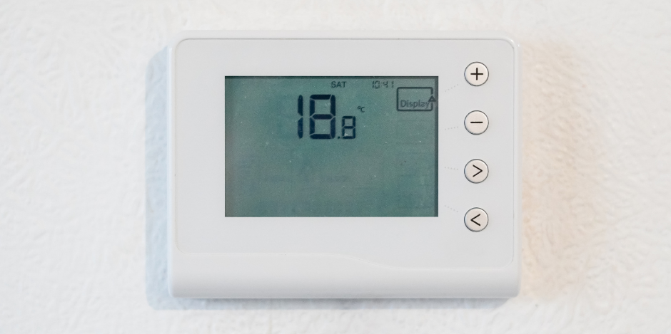 A white wall-mounted thermostat displays a temperature of 18.8 degrees Celsius with four circular control buttons.