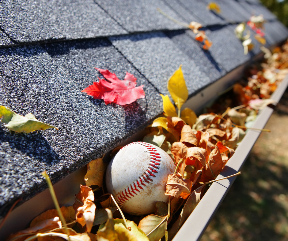 Clogged gutter filled with fallen leaves on a roof.