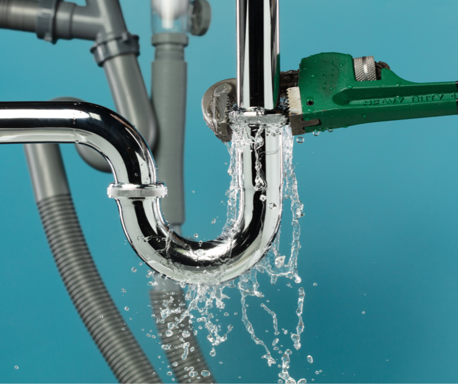 A green pipe wrench works on a leaking metal P-trap pipe under a sink, with water spraying against a blue background.