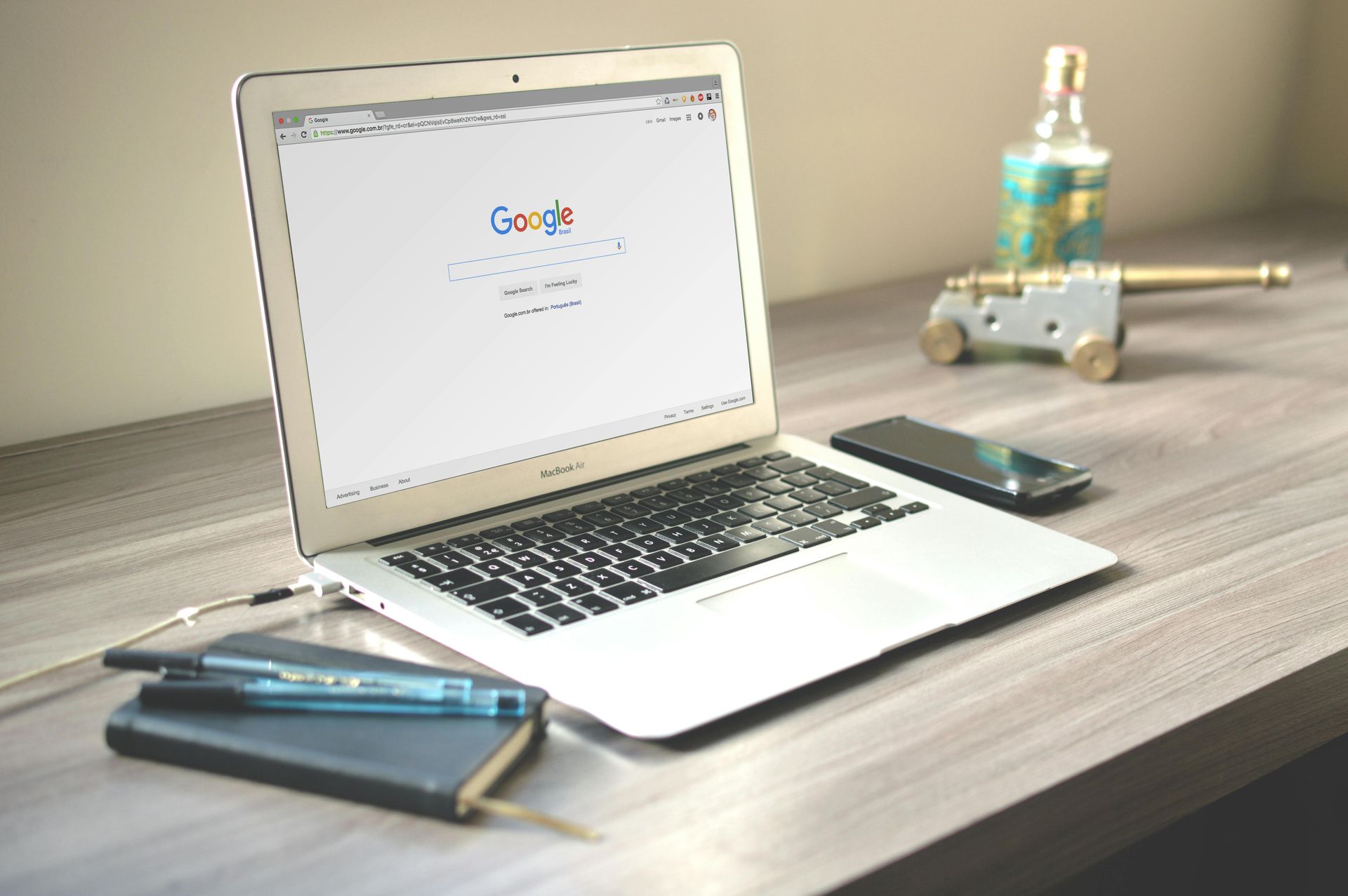 A laptop is open to a Google page on a wooden desk.