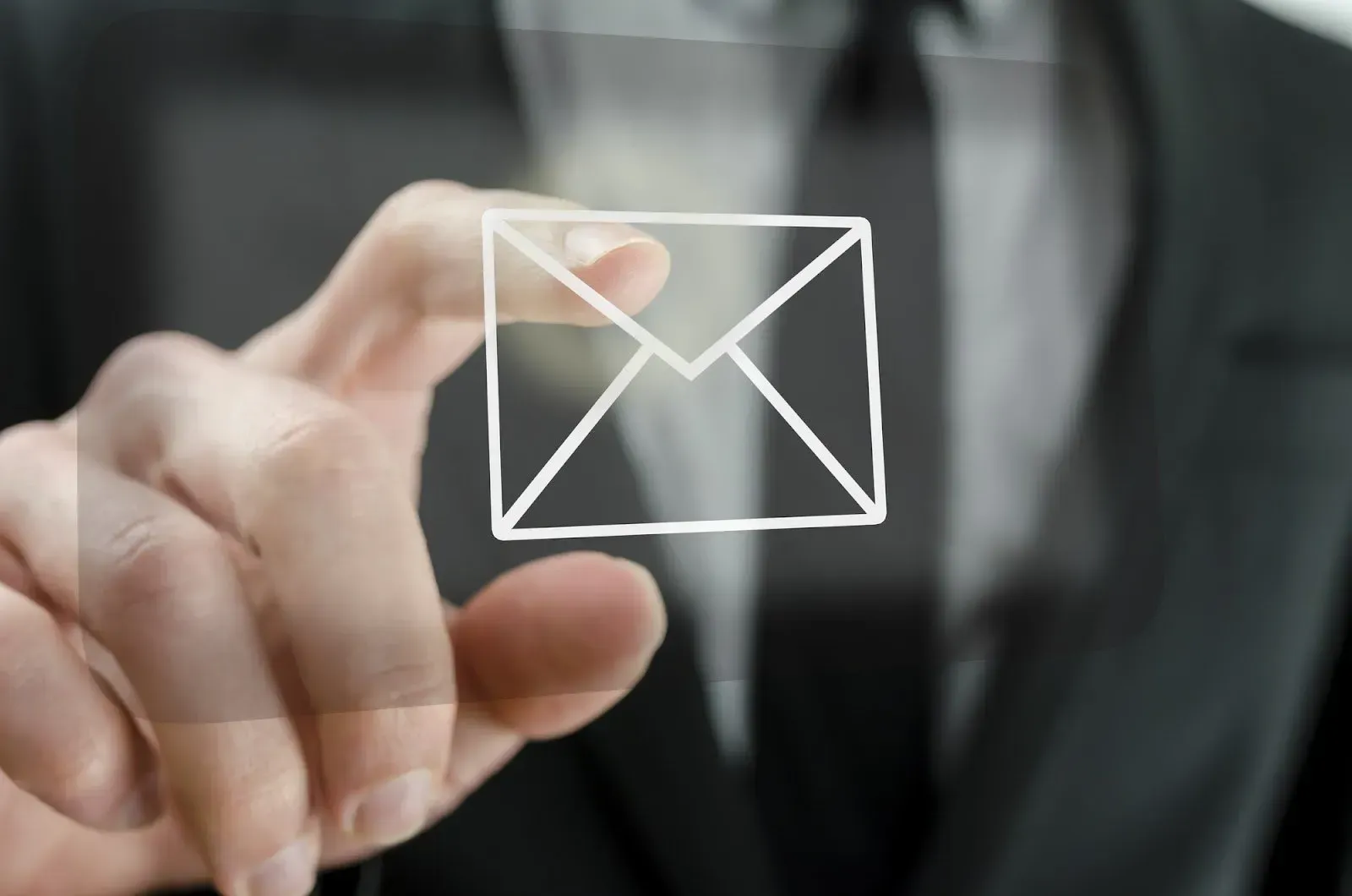 a man touching an email icon with his index finger