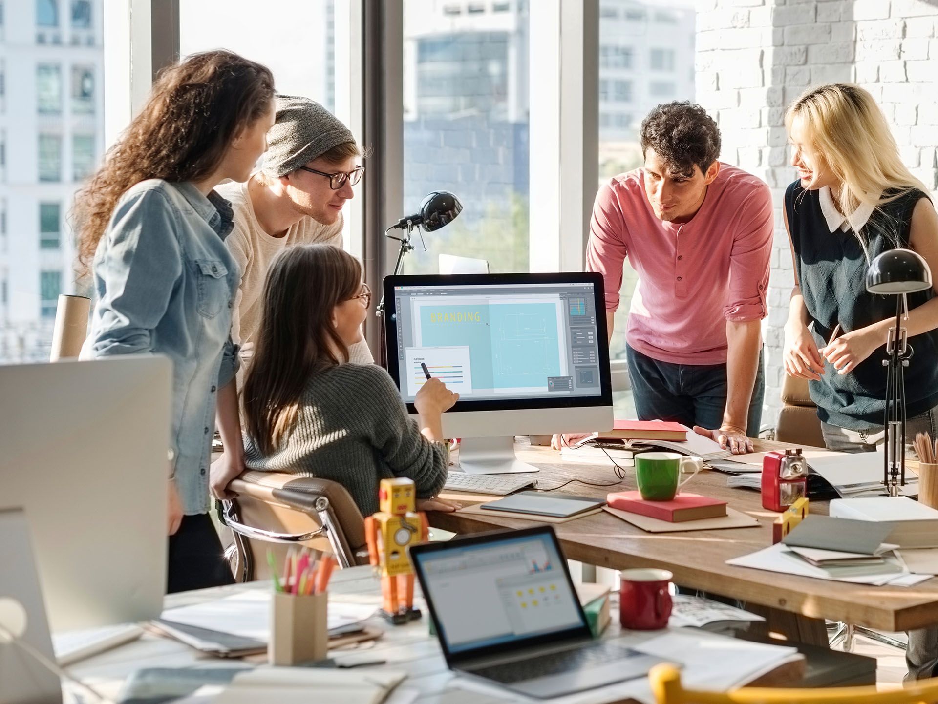A group of people are looking at a computer screen in an office.
