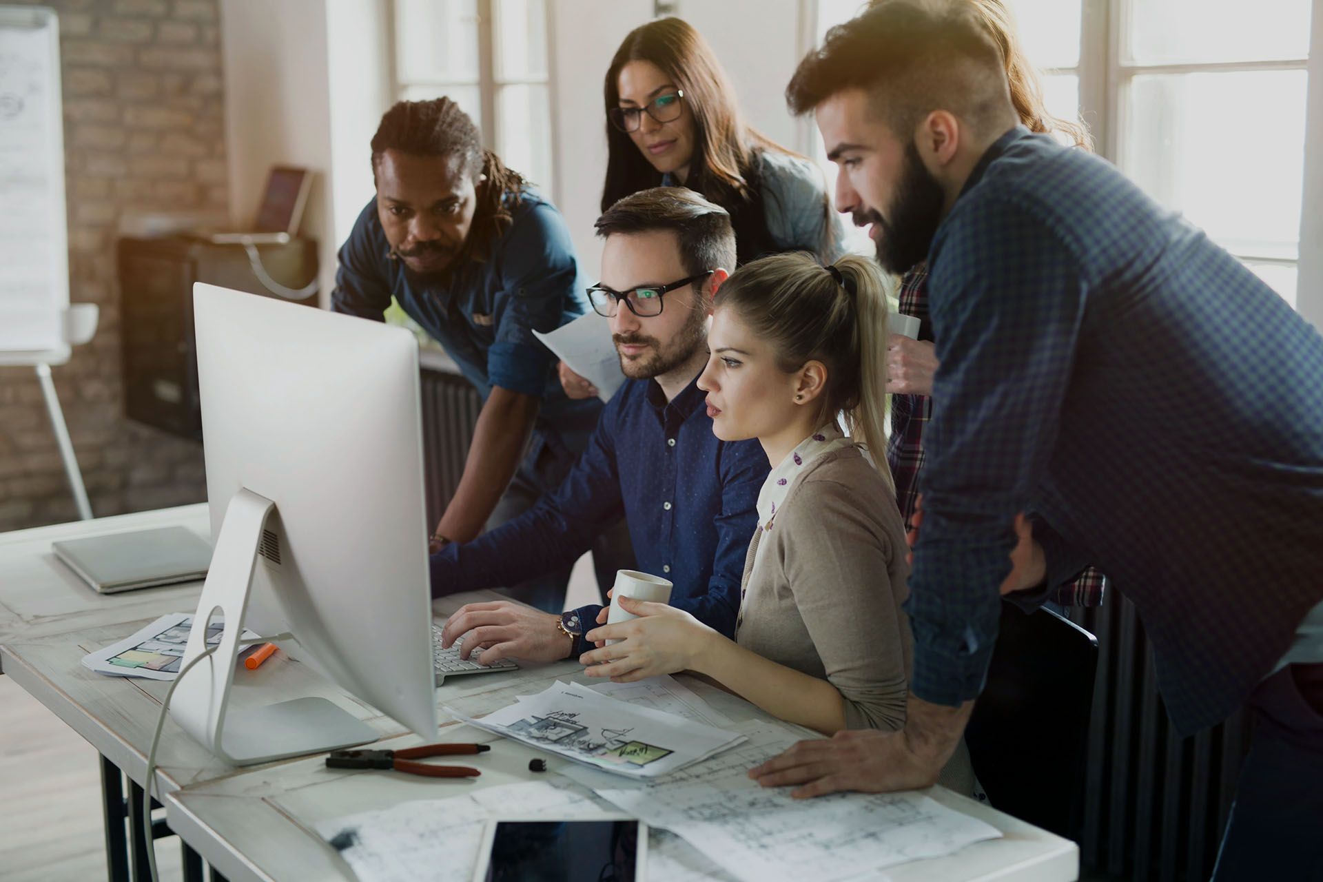 A group of people are looking at a computer screen.