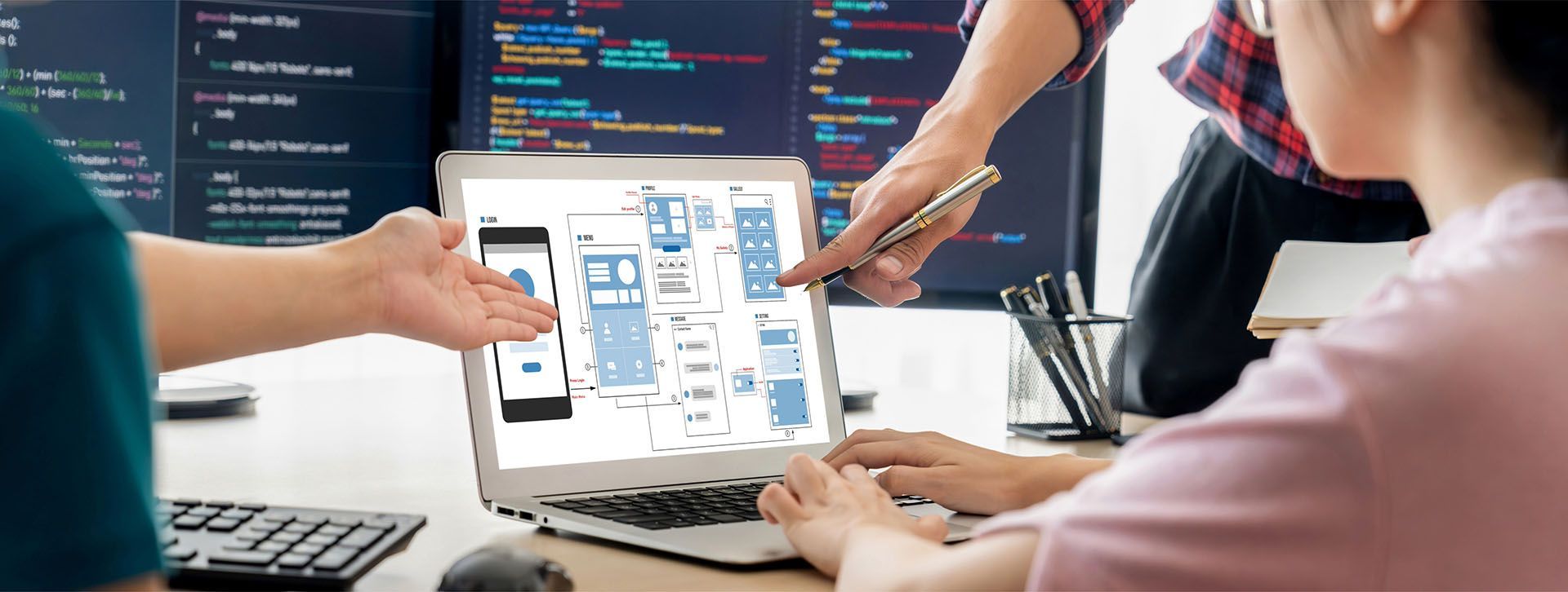 A group of people are working on a laptop computer.