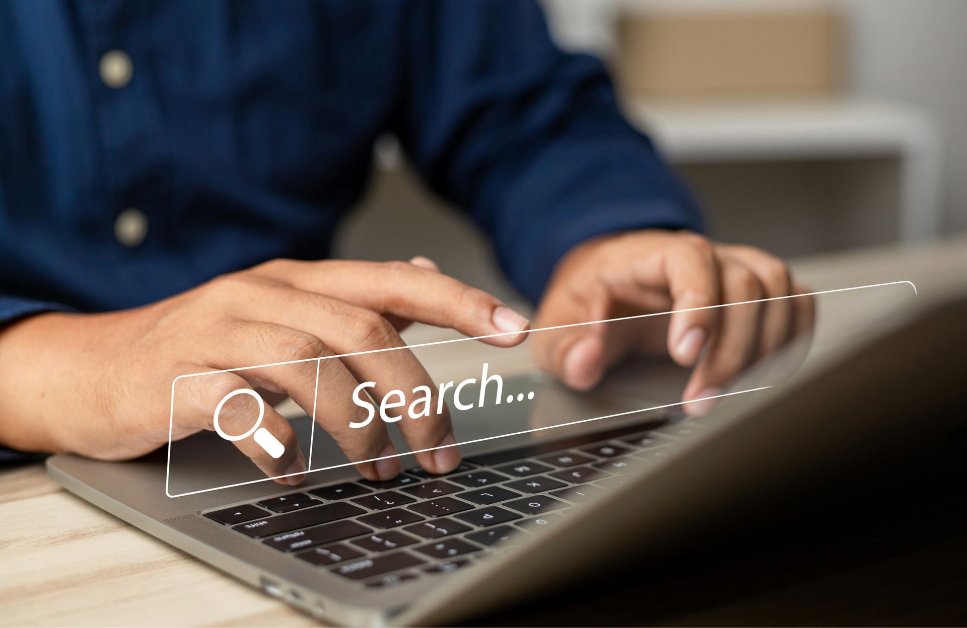 Person using a laptop, typing and searching online.