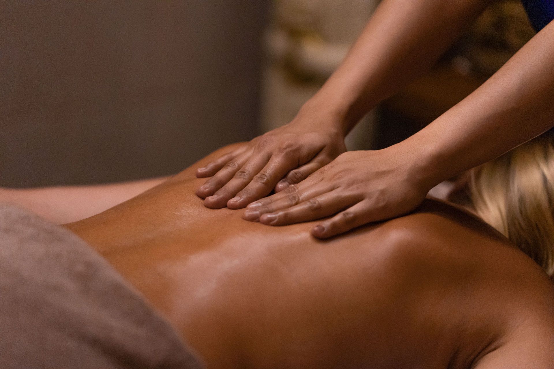 Hands giving a back massage in a spa.