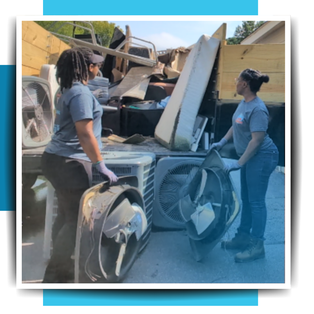two women putting trash in the trailer