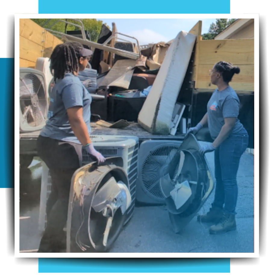 two women putting trash in the trailer