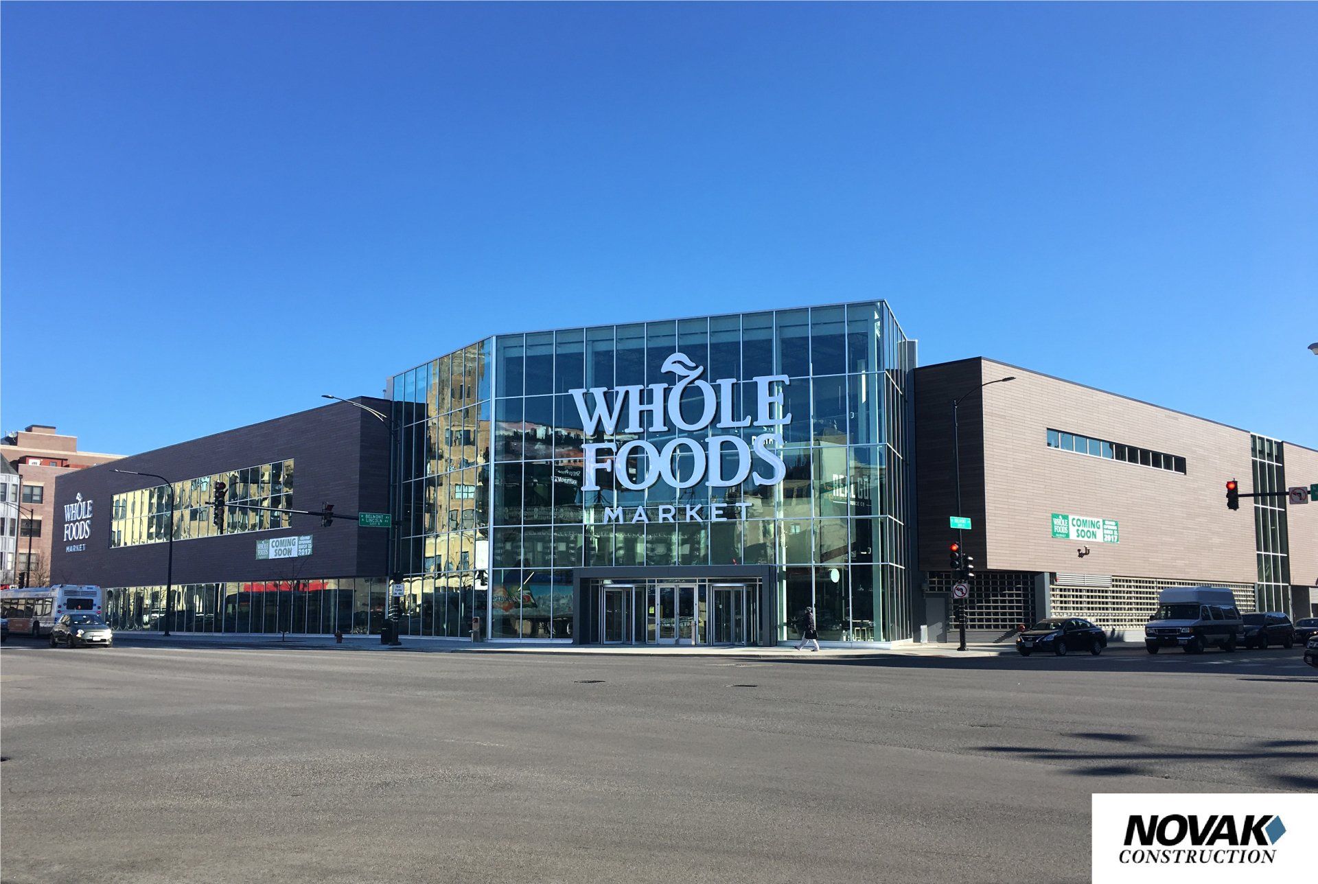 A whole foods store is located on the corner of a city street