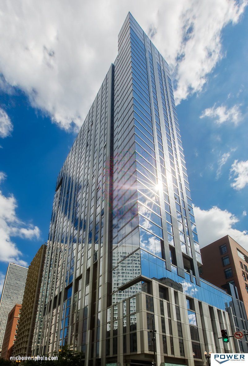 A tall building with a lot of windows is in the middle of a city.