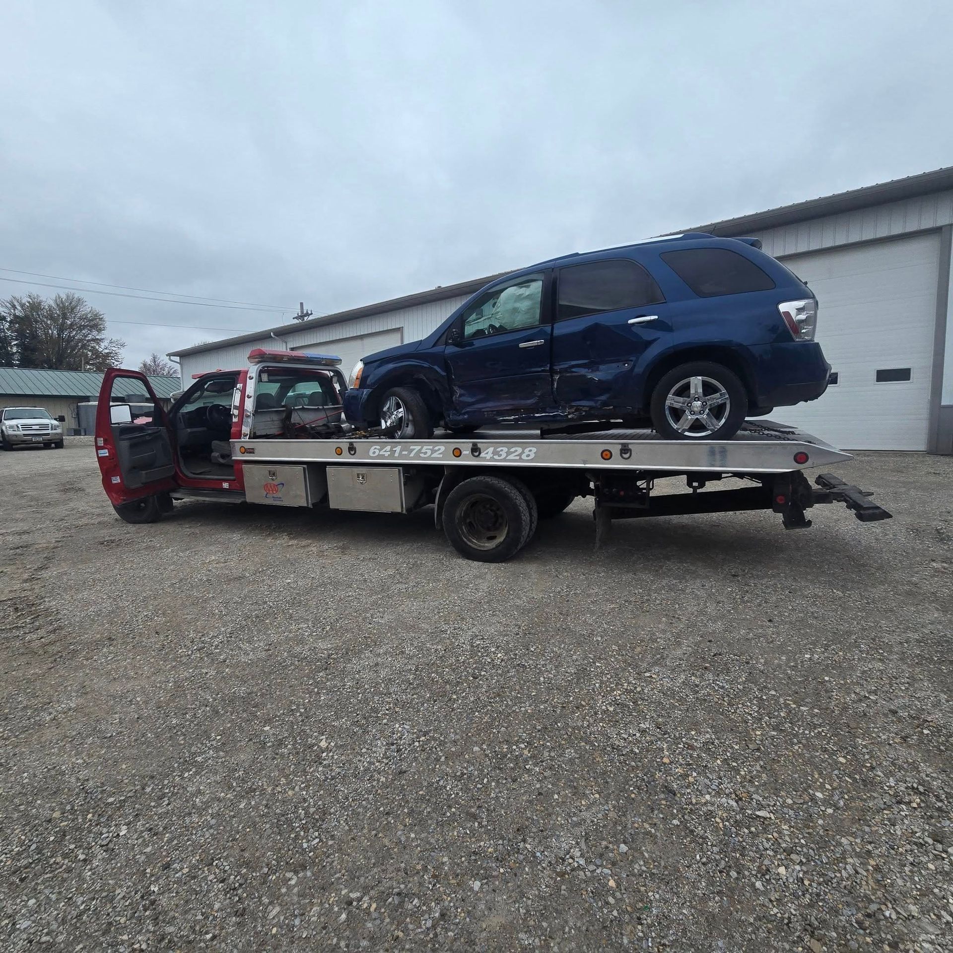 A blue suv is sitting on top of a tow truck.