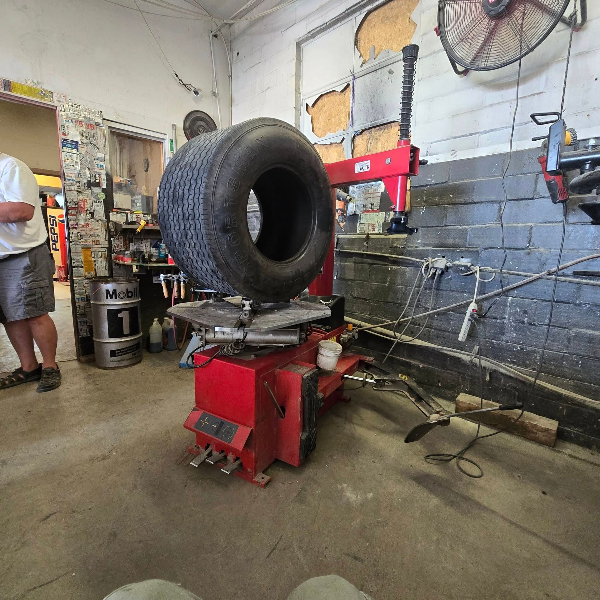 A tire is sitting on a tire changer in a garage