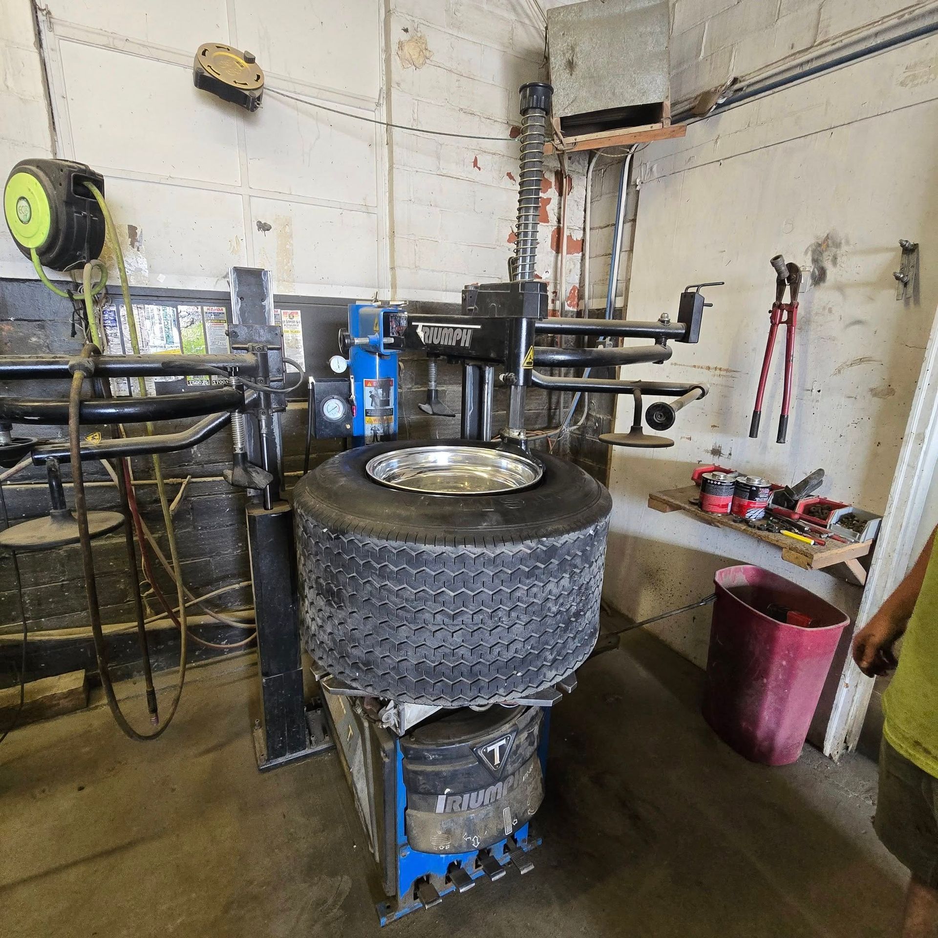 A tire is being changed on a machine in a garage