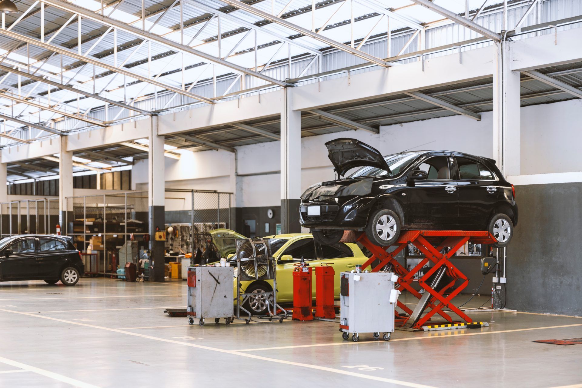 A car is sitting on top of a scissor lift in a garage.