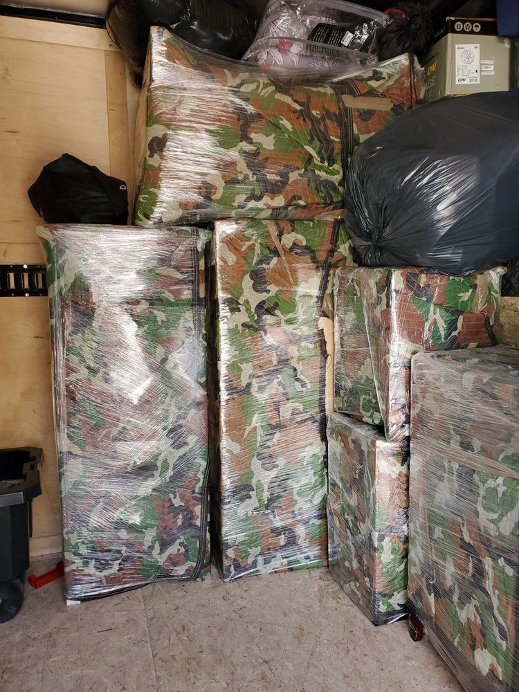 Packed moving van with camouflage-patterned mattresses.