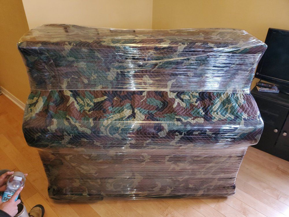 A large, wrapped piece of furniture in a camouflage pattern.