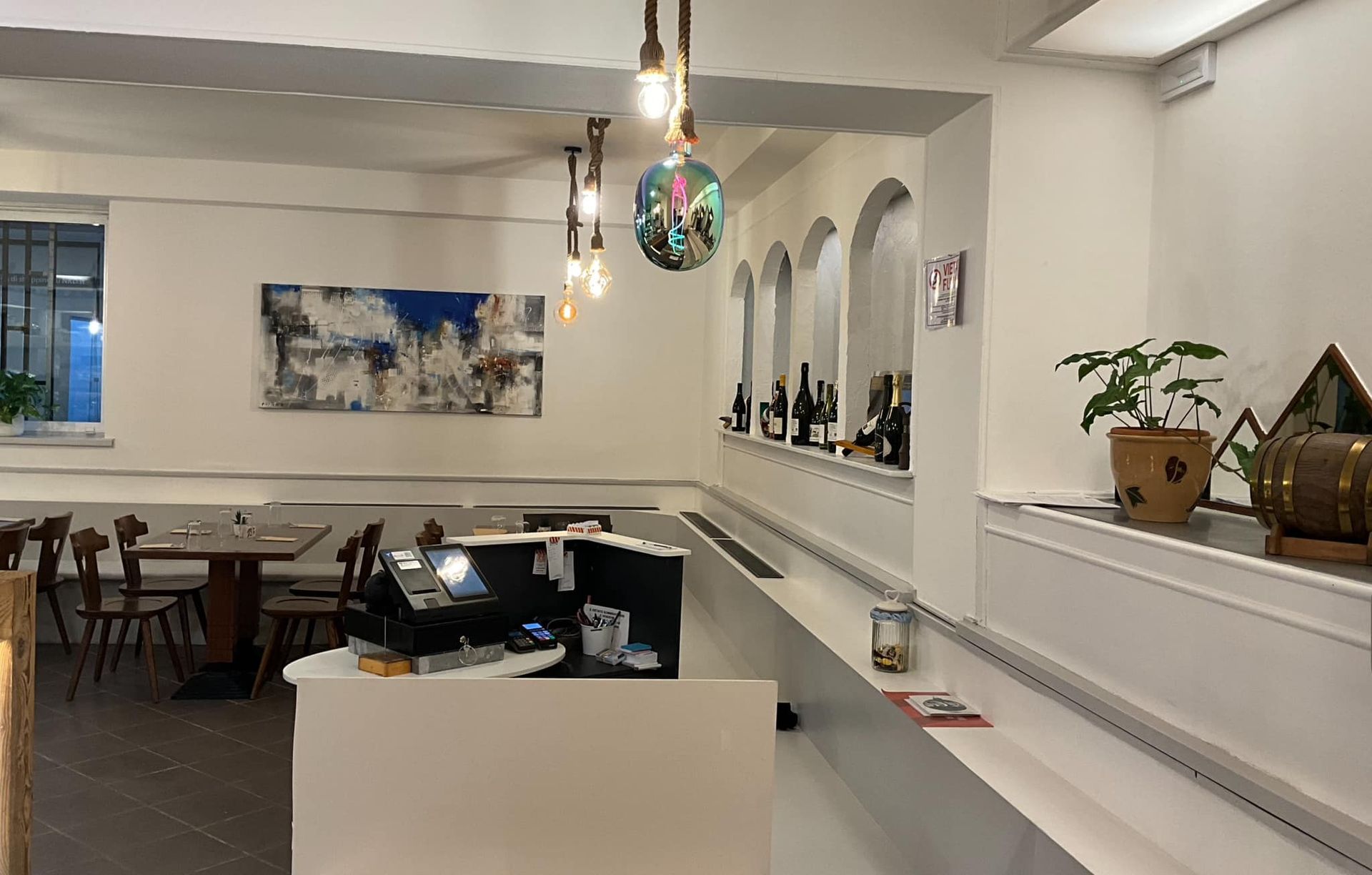 Un ristorante con tavoli, sedie e un bancone.