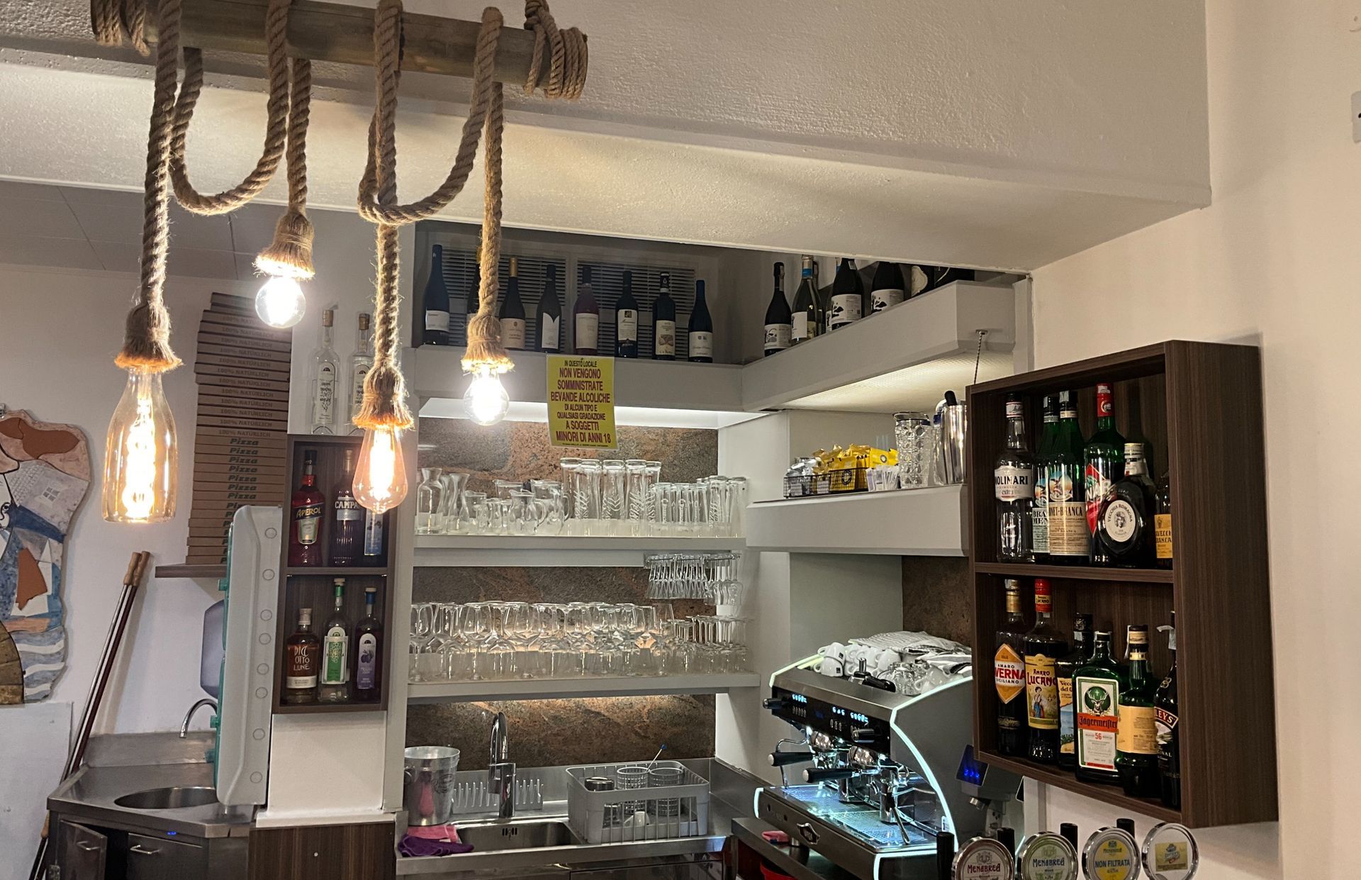 Una cucina con un sacco di bottiglie sugli scaffali.