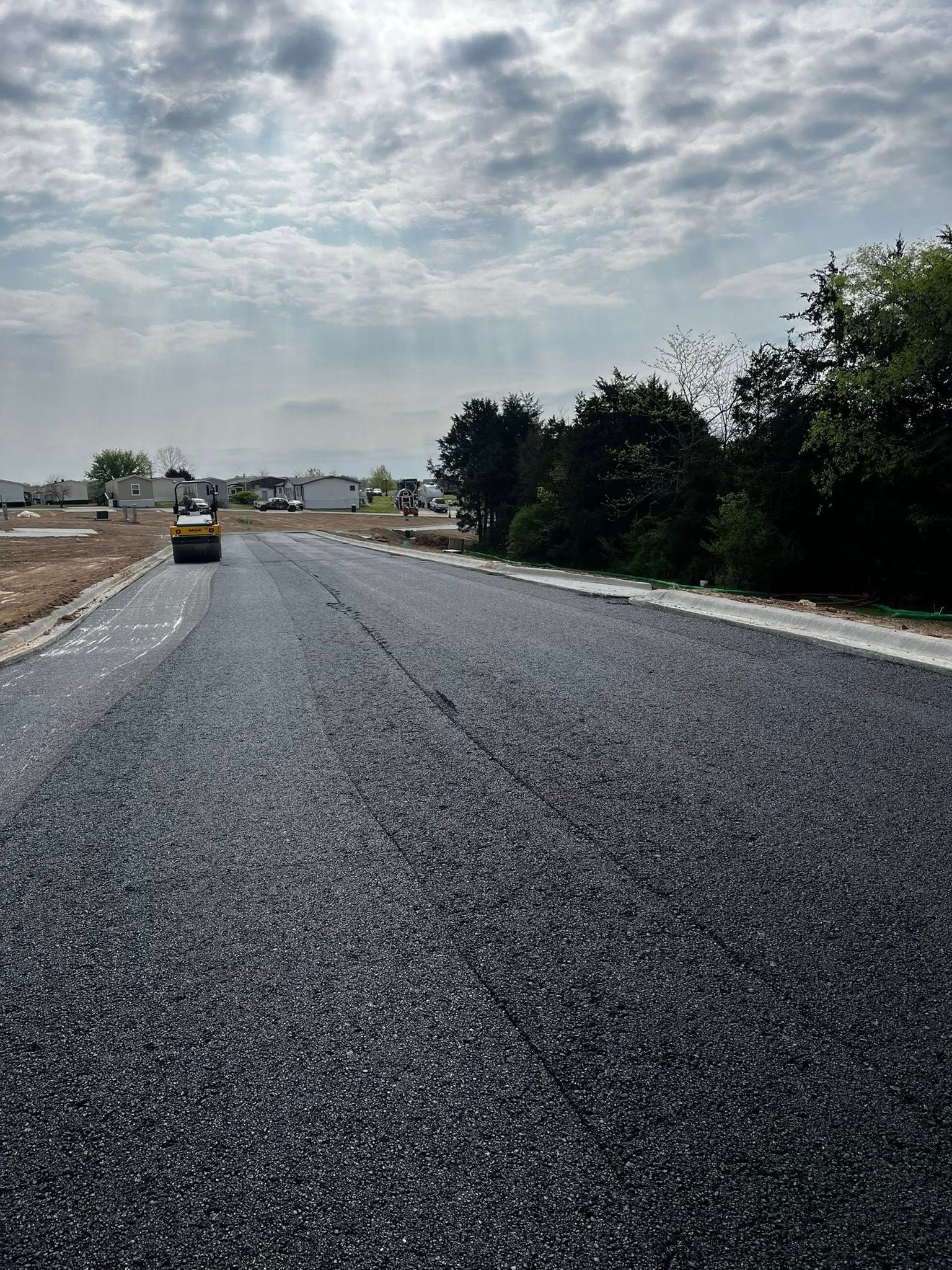 A roller is rolling asphalt on a road.