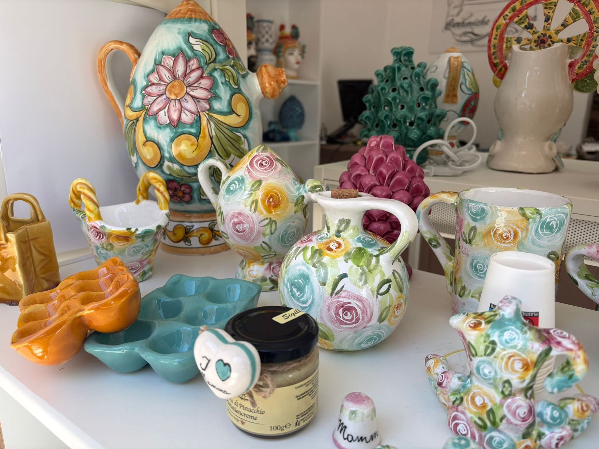 Una dozzina di pasticcini in miniatura in ceramica su un vassoio grigio decorativo.