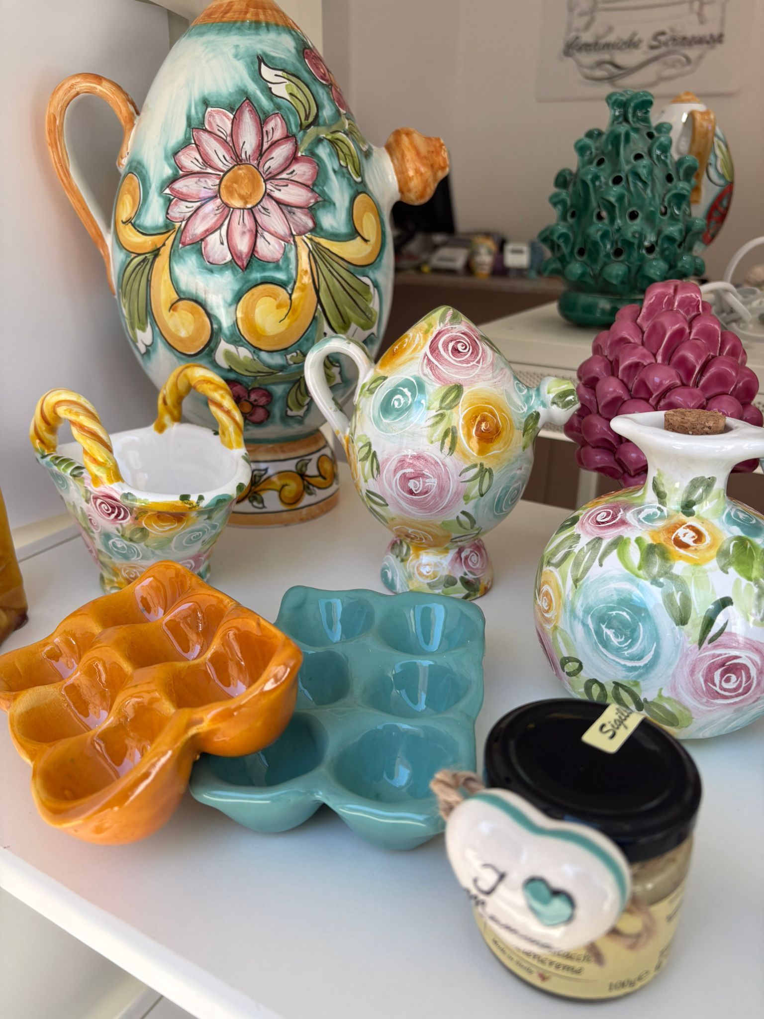 Decorazione raffigurante un melograno arancione con semi rossi, appeso a un albero di Natale verde.