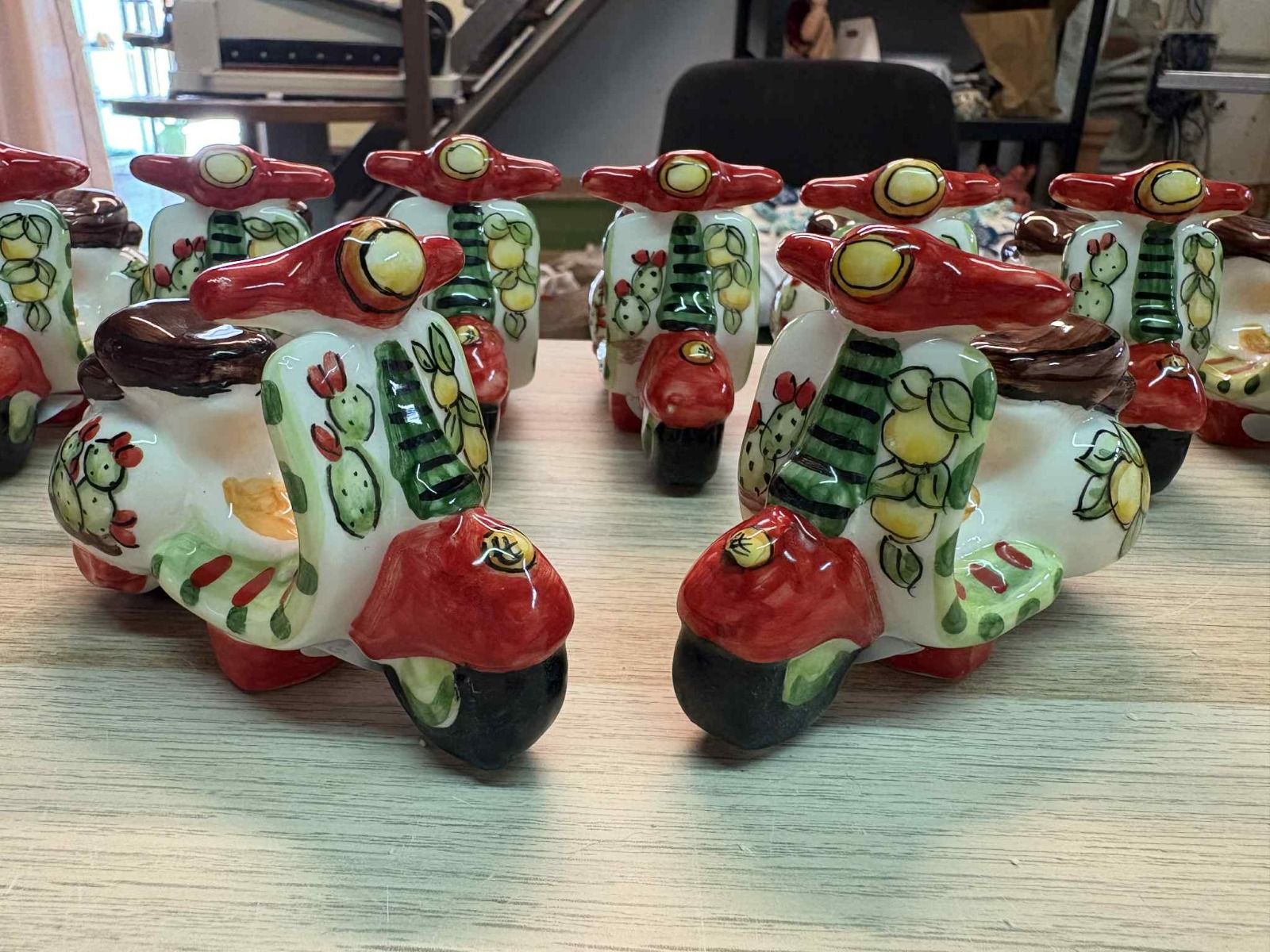 Tre sacchetti portaconfetti color avorio con ciondoli a forma di cuore, nastro e un centrotavola di calle in ceramica e pizzo.