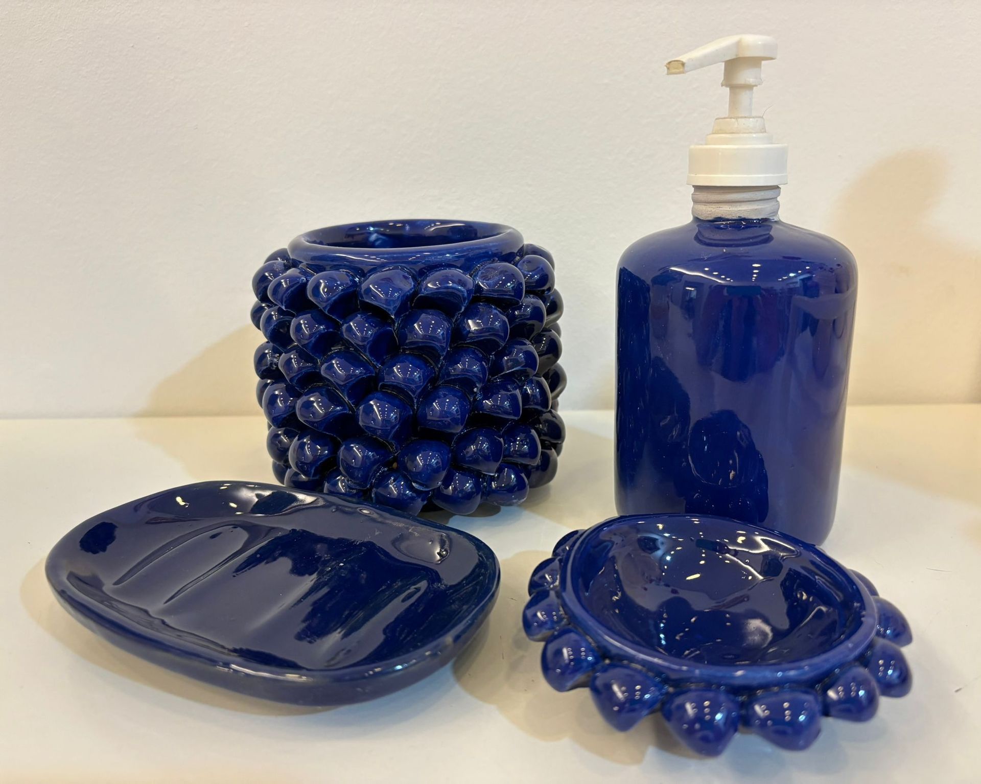 Decorazione murale con cactus, nuvole e un blocco geometrico grigio. Colori verde, blu e bianco.