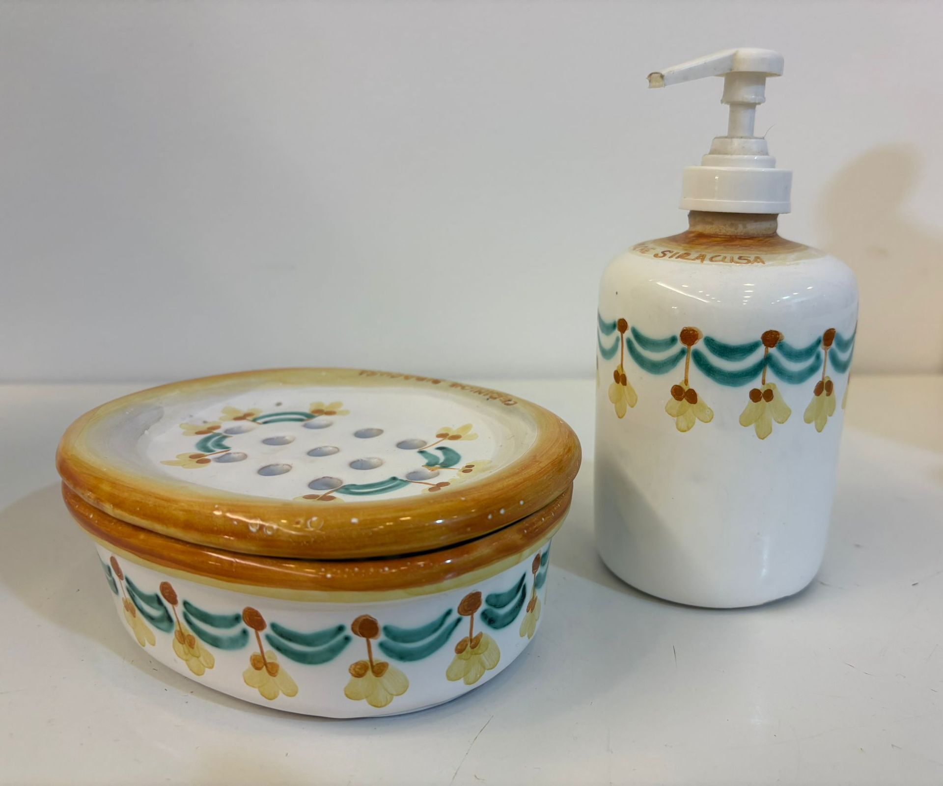 Dispenser di sapone in ceramica bianca con pompa, motivo floreale.