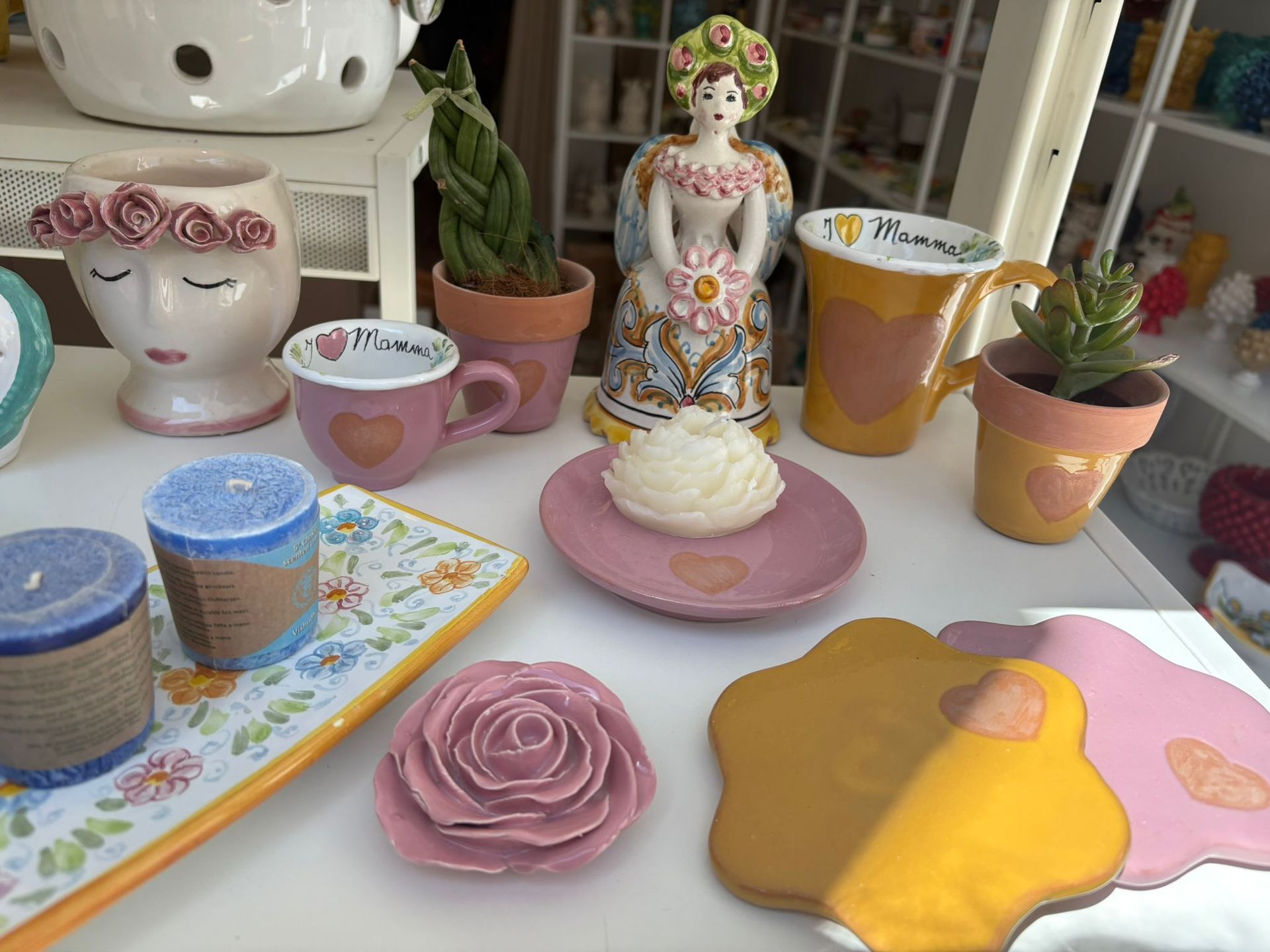 Una dozzina di pasticcini in miniatura in ceramica su un vassoio grigio decorativo.