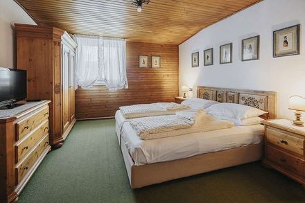 A bedroom with two beds , a dresser and a television.