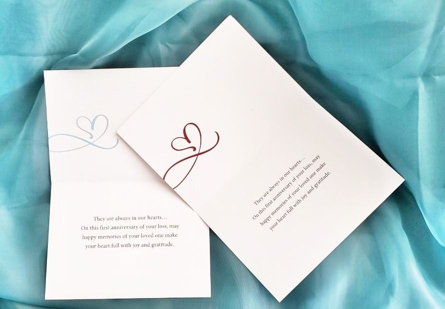 Two cards with hearts on them are sitting on a blue cloth