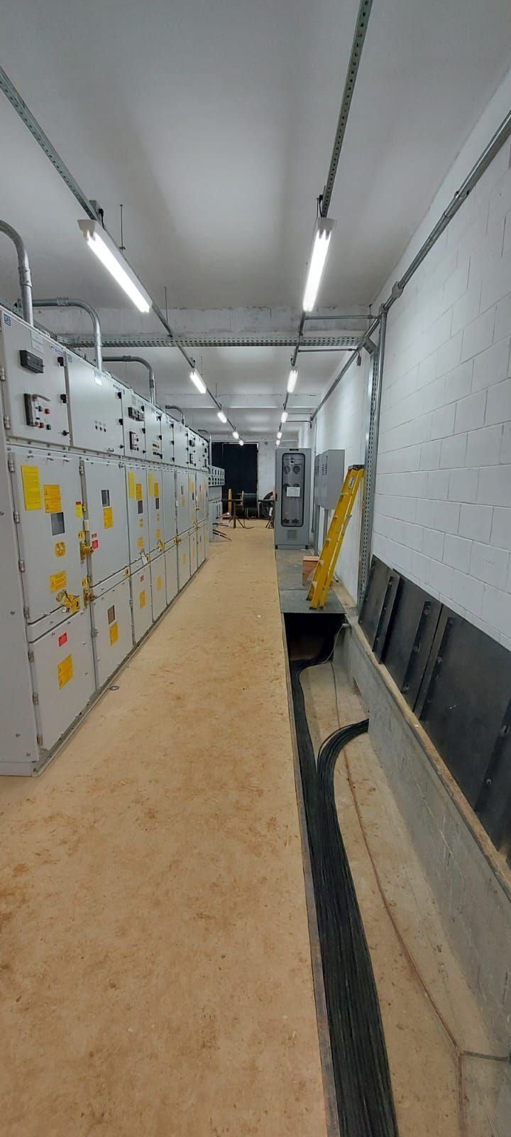 Um longo corredor cheio de muitos equipamentos elétricos em um prédio.