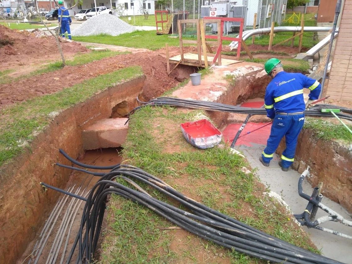 Um homem está parado em uma trincheira com um monte de fios.