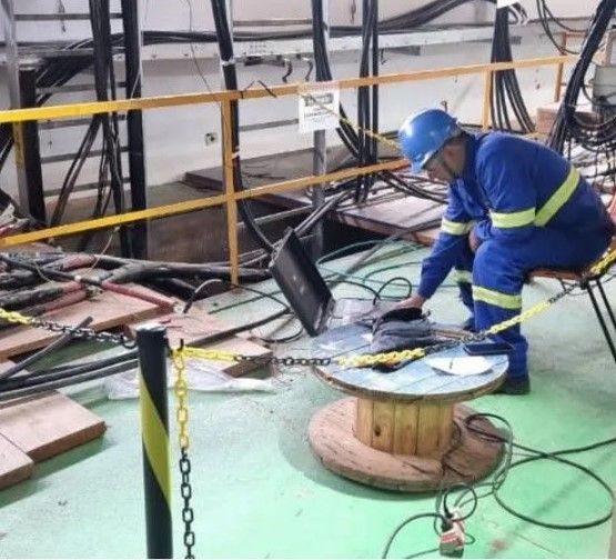 Um homem usando um capacete está trabalhando em um carretel de fios
