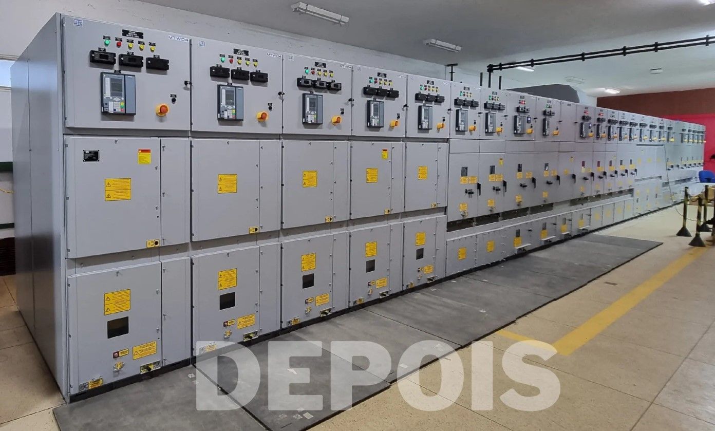 Uma fileira de caixas elétricas estão alinhadas em uma sala.
