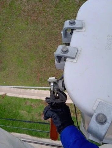 Uma pessoa está segurando uma chave inglesa em cima de um transformador.