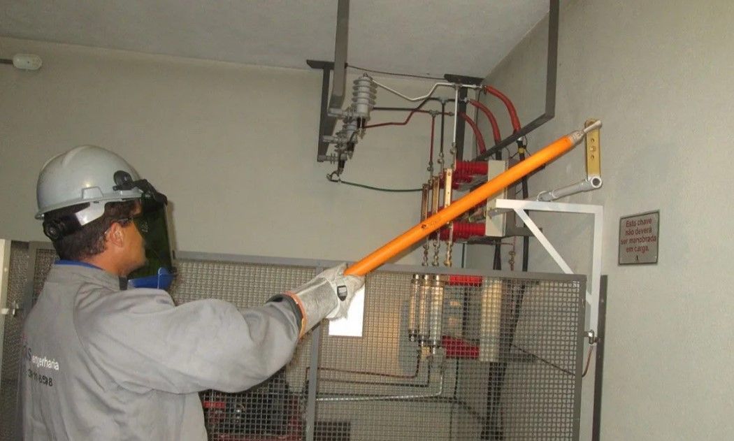 Um homem usando capacete e luvas está segurando um pedaço de pau em uma sala.