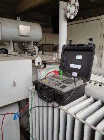 Uma máquina está em cima de um transformador em uma sala.