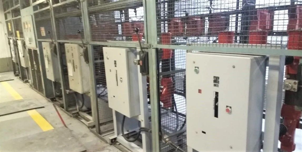 Uma fileira de caixas elétricas estão alinhadas em uma sala.