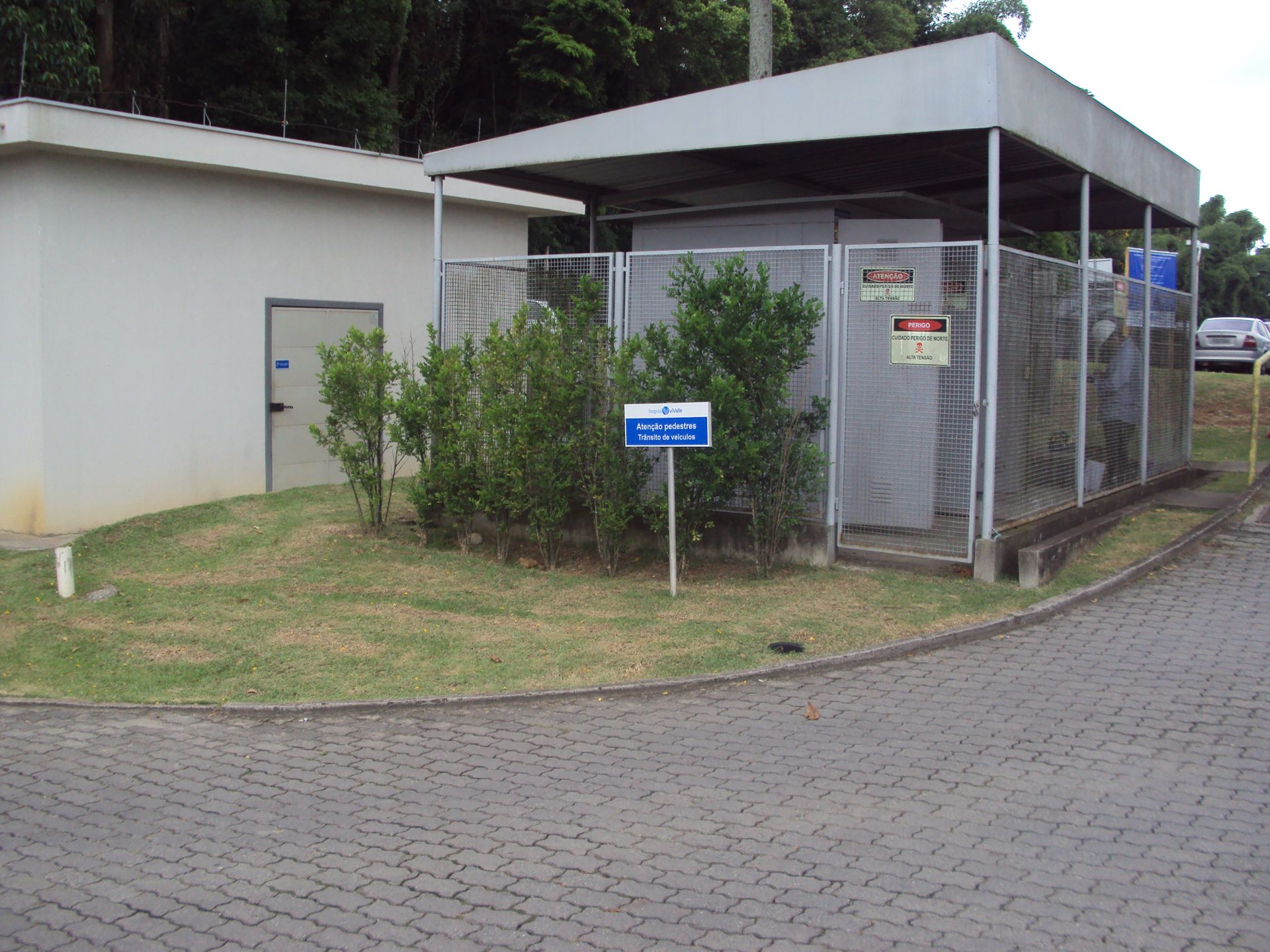 Um prédio com uma cerca ao redor e uma placa que diz 'segurança'