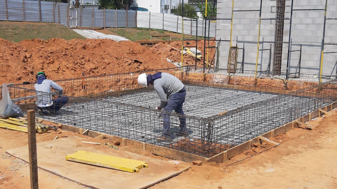 Um grupo de trabalhadores da construção civil está trabalhando em um canteiro de obras.