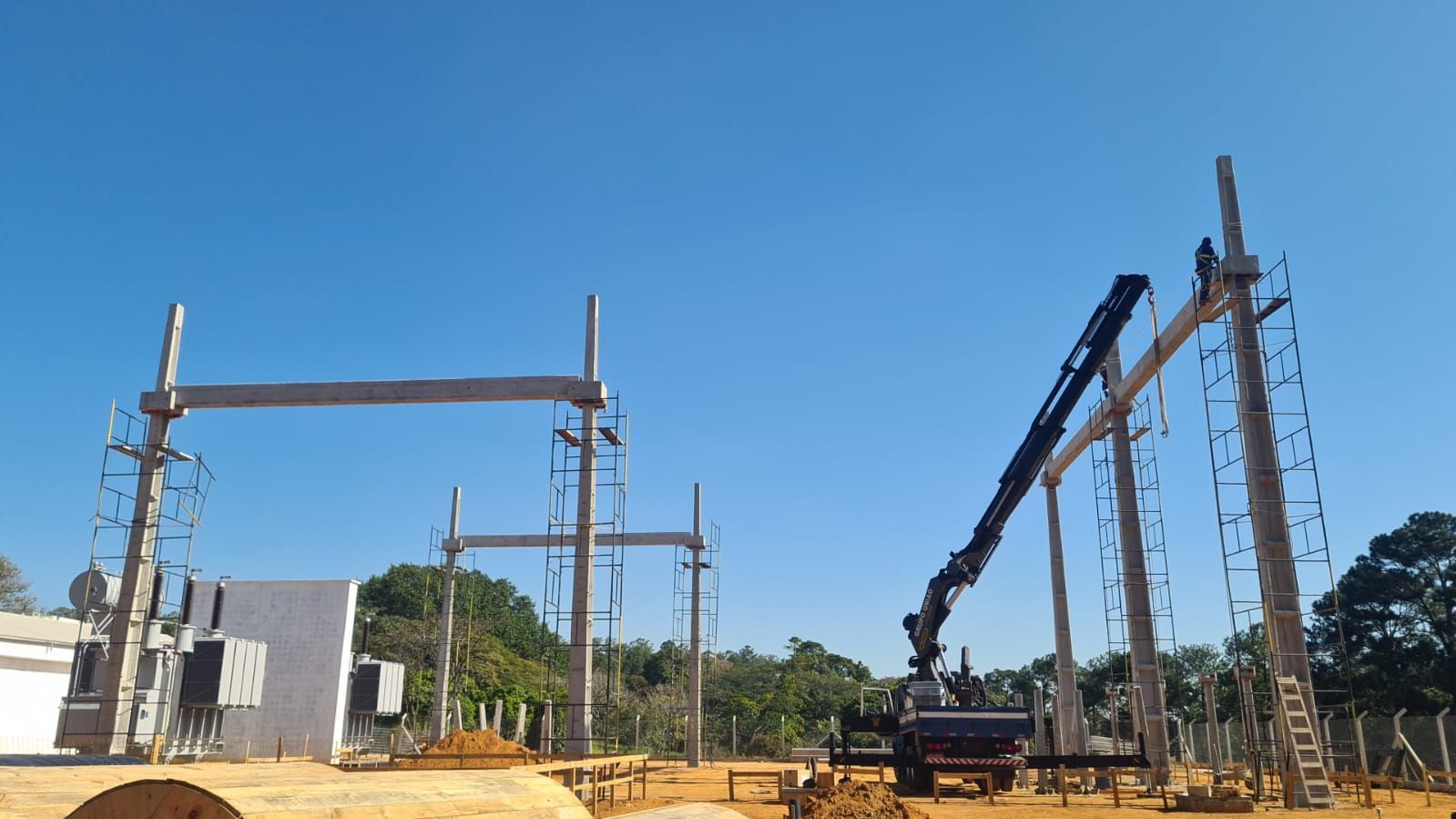 Um canteiro de obras com um guindaste e um prédio ao fundo.
